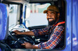 © Drazen - Happy black driver driving his truck and looking at camera.