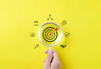 Business growth and marketing target concepts. Holding a magnifying glass with aim bullseye icon and other business icons. Goal objective strategy plan action, Target success, Achievement company,