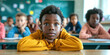 © Valeriia - Portrait of a curious African American elementary school young boy in hoodie sitting in an ordinary classroom. Availability of education in countries concept