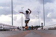 © Manu Prats - Asian skateboarder with free spirit joining street sports riding over a bridge at dusk, Philippines