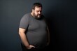 Fat man suffering from stomach ache, studio shot on black background. Overweight and obesity concept. Obesity Concept with Copy Space.