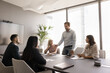 © fizkes - Serious business professional man holding meeting with partners. Manager presenting project plan to colleagues at large table in boardroom. Boss giving work instructions to employees