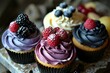 a group of cupcakes with frosting and berries