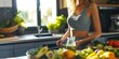 Fit woman in good shape standing in the kitchen, preparing a healthy smoothie food