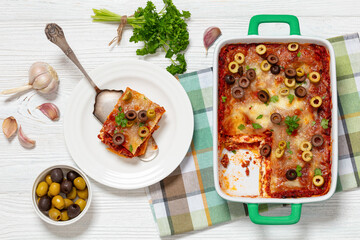 Wall Mural - lasagna with olive rings in green baking dish