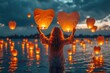 Hands releasing heart-shaped paper lanterns into the night sky