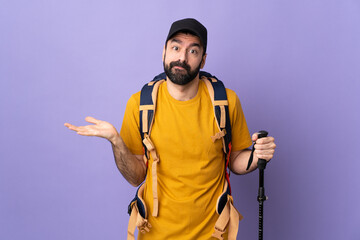 Wall Mural - Caucasian handsome man with backpack and trekking poles over isolated background having doubts while raising hands