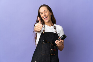 Young hairdresser woman over isolated background with thumbs up because something good has happened