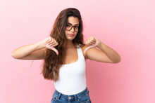 Young Caucasian Woman Isolated On Pink Background Showing Thumb Down With Two Hands