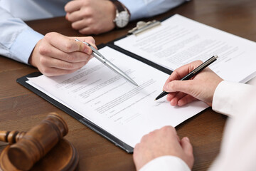 Wall Mural - Lawyers working with documents at wooden table, closeup