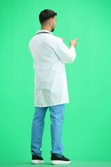 The doctor, in full height, on a green background, points forward