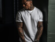 Mockup of a black man with tattoos wearing a white T-shirt