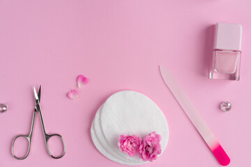 Wall Mural - Salon manicure concept photo. Manicure equipment with nail polish and rose petals pink background top view space for text