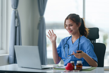 Doctor or nurse consulting with patient online using laptop computer in hospital.