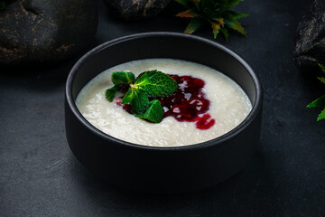 Poster - Boiled rice with cherry jam and mint in bowl on dark background.