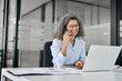 © insta_photos - Happy smiling middle aged business woman bank manager, senior professional lady talking on phone making business call on telephone at customer service work in office using laptop sitting at desk.