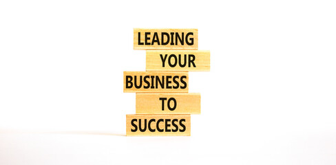 Wall Mural - Leading your business to success symbol. Concept words Leading your business to success on wooden blocks. Beautiful white table white background. Leading your business to success concept. Copy space.