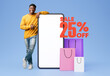 © Prostock-studio - Black Guy Pointing At Empty Phone Posing With Shopper Bags