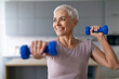 © Prostock-studio - senior woman enjoys morning workout with weights in living room
