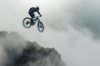 Silhouette of mountain biker jumping in foggy trail