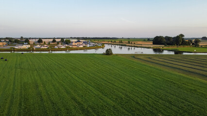 Aerial drone view of harbor, marina and industrial area in Steenwijk, The Netherlands. Company buildings next to canal surrounded by nature farmland meadow landscape captured from above. 