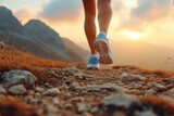 Fototapeta  - Athletic female legs in sneakers at the backdrop of rocky landscape at dawn. Concepts: sports, healthy lifestyle, strength, endurance, beautiful body, sports shoes, active recreation