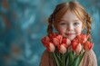 © Irina Mikhailichenko - portrait of a charming smiling little girl with a bouquet of tulips in her hands. lifestyle. fresh flowers. International Women's Day. space for text. High quality photo