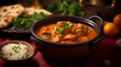 Chicken Tikka Masala in an earthen bowl with various ingredients and spices nearby