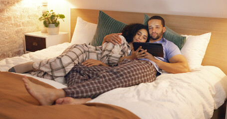 Sticker - Couple, happy and relax in bedroom with tablet at night, streaming movie and hug. Smile, technology and man and woman in bed on social media app, watching online video and bonding together in home.