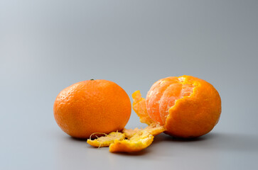 Wall Mural - Two ripe tangerine fruits on a gray background