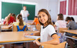 © JackF - Portrait of girl sitting at desk in classroom during lesson, looking back at camera.