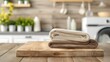 A neat pile of soft towels adds a touch of warmth to the sleek and modern kitchen, resting upon a rustic wooden table with a smooth surface
