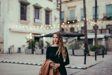 Wall Mural - Chica rubia joven posando con vestido negro en la calle