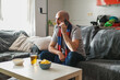 Man talking on the phone while watching sports on the sofa