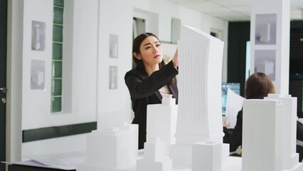 Poster - Graphic artist developing architectural 3d building, comparing blueprints of papers with scale drafts on tablet. Creative engineer working at coworking space small business, architecture agency.