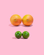© ChristopherTP - Raw oranges and lemons on pink background, concept of female breasts of different sizes