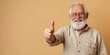 smiling elderly gray-haired man in glasses shows thumbs up on a colored background in the studio, pensioner, old age, grandfather, portrait of a mature person, beard, casual wear, gesture, happy