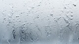 Fototapeta Tęcza - Spots of raindrops sticking to the glass against a gray background.