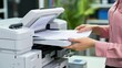 Worker's hands at work printing data sheets in a laser printer at the office. Business Documents concept