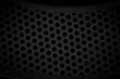 abstract background of black perforated metal with holes in it