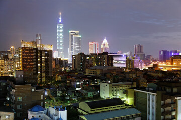 Wall Mural - Night skyline of Downtown Taipei, vibrant capital city of Taiwan, with the famous landmark 101 Tower standing among high-rise buildings in Xinyi Financial District and city lights dazzling in the dark