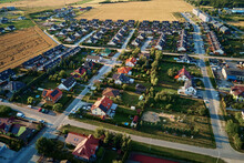 Residential Houses In Small Town Near Agricultural Field, Bird Eye View. Aerial View Of European Suburban Neighborhood With Townhouses. Real Estate In Poland