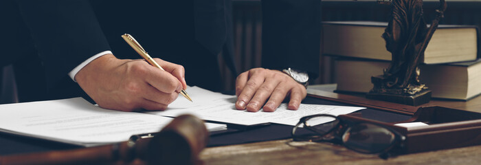 Wall Mural - Lawyer working with document at wooden table in office, closeup. Banner design