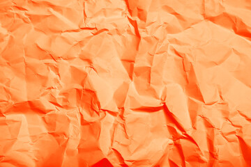 Sheet of orange crumpled paper as background, top view