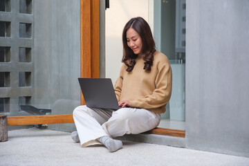 Wall Mural - portrait image of a young woman working on laptop computer at home