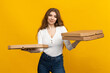 © makedonski2015 - This image captures the essence of a busy delivery service, with a smiling woman balancing a stack of pizza boxes on a sunny yellow background