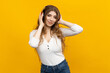 © makedonski2015 - A stunning young female immerses herself in music as she listens to it with headphones, surrounded by a bright yellow ambiance. This portrays a passionate music enthusiast