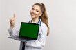 © makedonski2015 - A smiling female doctor in a white coat holds a laptop with a chromakey . The concept of advertising medical services in the hospital. Online consultations