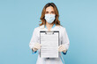 Female doctor woman wear white medical gown suit mask gloves work in hospital clinic office hold clipboard registration form document isolated on plain blue background. Health care medicine concept.