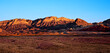 Coucher de soleil sur Red Rock Mountain, Las Vegas, Nevada, États-Unis d'Amérique. Montagne à la roche en strates or et rouge en arrière-plan d'un désert sec de cailloux et de poussière.